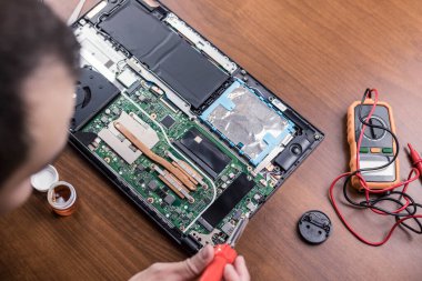 Teknisyen dizüstü bilgisayarı tamir ediyor. Lehim elektroniği pc parçaları.