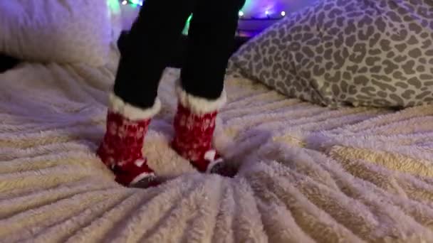 Egy Lány Vicces Piros Karácsonyi Zokni Ugrik Ágyra Háttér Díszített — Stock videók