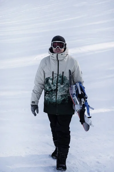Hombre Con Una Tabla Snowboard Mano Camina Por Una Ladera —  Fotos de Stock