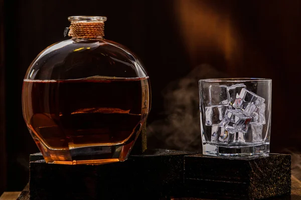 Czarny Lakierowany Drewniany Stół Butelką Whisky Szklanką Lodem Czarne Tło — Zdjęcie stockowe