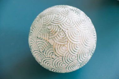 Mavi arka planda top, boyanmış noel topu, gri ve beyaz renk.