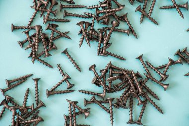 Yeşil arkaplanda siyah başlıklı vida, yüksek açılı görünüm