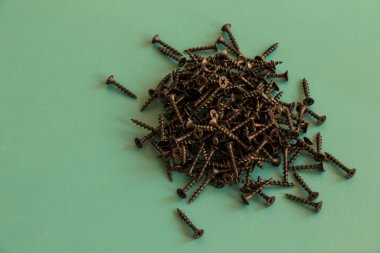 Yeşil arkaplanda siyah başlıklı vida, yüksek açılı görünüm