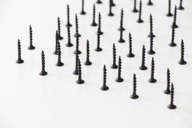 Beyaz arkaplanda siyah başlıklı vida, yüksek açılı görünüm ve siyah beyaz renkler