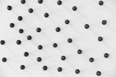 Beyaz arkaplanda siyah başlıklı vida, yüksek açılı görünüm ve siyah beyaz renkler