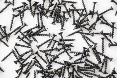 Beyaz arkaplanda siyah başlıklı vida, yüksek açılı görünüm ve siyah beyaz renkler