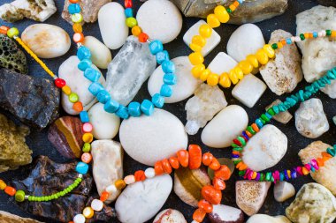Renkli kolye ve bilezik karışımı, boncuklar ve taş kolye, taştan arka planda mücevherler.