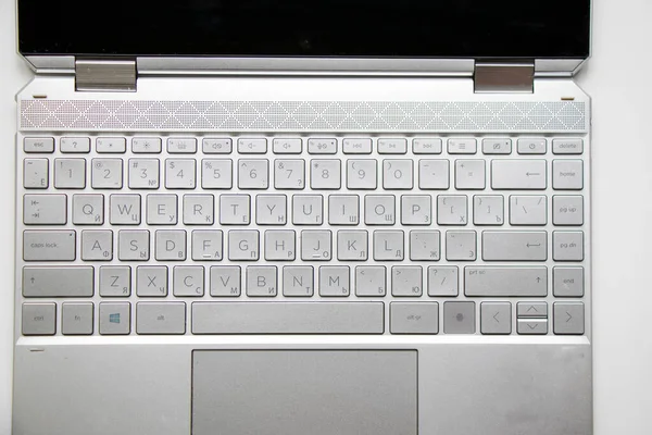 Laptop and notebook computer keyboard close-up, texts, keys and gray board.