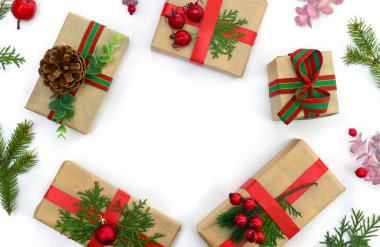 Noel süsü. Hediye kutuları, yılbaşı ağacı dalları, beyaz arka planda kırmızı böğürtlenler ve mesaj için yer. Üst manzara, düz uzanma