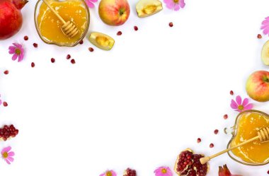 Frame of honey in glass bowl, red apples, garnets, wooden honey dipper, pink flowers on a white background with space for text. Top view, flat lay