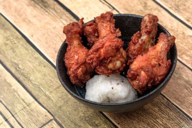 Kızarmış tavuk, buğulanmış pirinç, arka planda Asya sokak yemekleri.