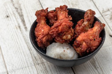 Kızarmış tavuk, buğulanmış pirinç, arka planda Asya sokak yemekleri.