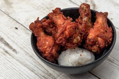 Kızarmış tavuk, buğulanmış pirinç, arka planda Asya sokak yemekleri.