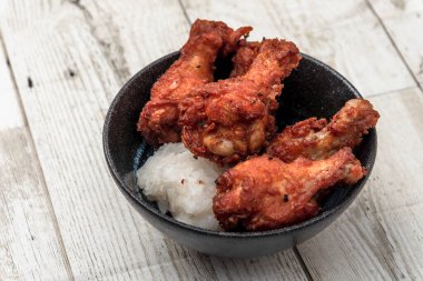 Kızarmış tavuk, buğulanmış pirinç, arka planda Asya sokak yemekleri.