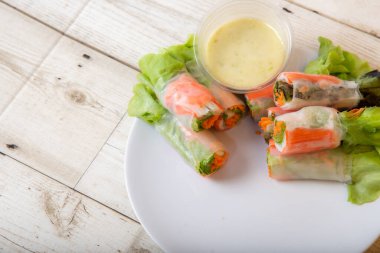 Asya caddesinde taze sebze salatası rulosu. Yiyecek tüpü. Ahşap zeminde izole edilmiş.