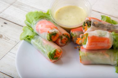 Asya caddesinde taze sebze salatası rulosu. Yiyecek tüpü. Ahşap zeminde izole edilmiş.