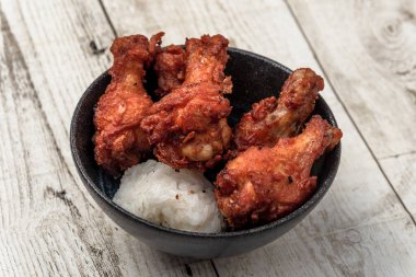 Kızarmış tavuk, buğulanmış pirinç, arka planda Asya sokak yemekleri.