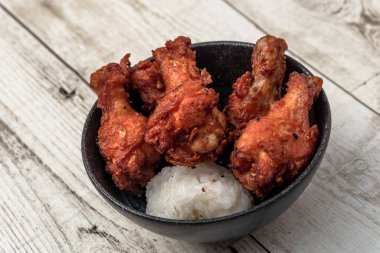 Kızarmış tavuk, buğulanmış pirinç, arka planda Asya sokak yemekleri.