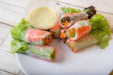 Asya caddesinde taze sebze salatası rulosu. Yiyecek tüpü. Ahşap zeminde izole edilmiş.