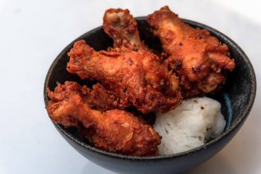 Kızarmış tavuk, buğulanmış pirinç, arka planda Asya sokak yemekleri.