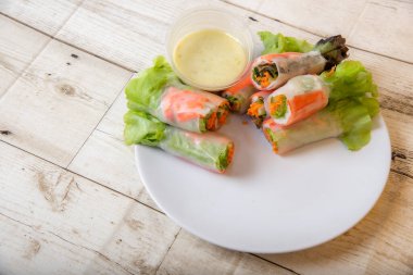 Asya caddesinde taze sebze salatası rulosu. Yiyecek tüpü. Ahşap zeminde izole edilmiş.