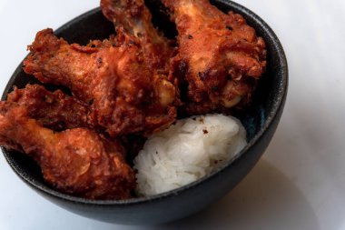 Kızarmış tavuk, buğulanmış pirinç, arka planda Asya sokak yemekleri.