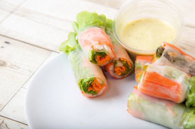 Asya caddesinde taze sebze salatası rulosu. Yiyecek tüpü. Ahşap zeminde izole edilmiş.