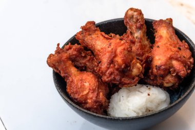 Kızarmış tavuk, buğulanmış pirinç, arka planda Asya sokak yemekleri.