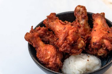 Kızarmış tavuk, buğulanmış pirinç, arka planda Asya sokak yemekleri.