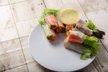 Asya caddesinde taze sebze salatası rulosu. Yiyecek tüpü. Ahşap zeminde izole edilmiş.