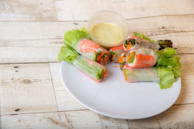 Asya caddesinde taze sebze salatası rulosu. Yiyecek tüpü. Ahşap zeminde izole edilmiş.