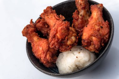 Kızarmış tavuk, buğulanmış pirinç, arka planda Asya sokak yemekleri.