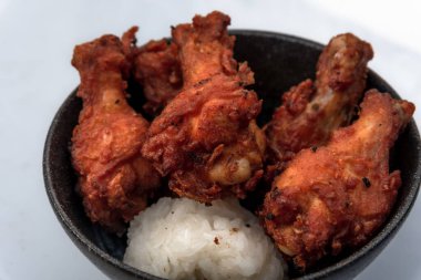 Kızarmış tavuk, buğulanmış pirinç, arka planda Asya sokak yemekleri.