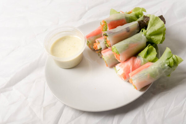 Fresh vegetable salad roll in noodle tube on dish isolated on white background Asian street food