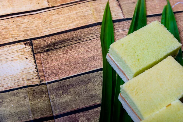 Pandan cake on the wooden floor sweet, soft, delicious food background with high resolution