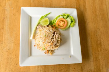 Ahşap zeminde satılık bir tabakta kızarmış domuz pirinci.