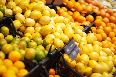 Süpermarkette satılan turunçgiller, limonlar, portakallar, kutularda limonlar.