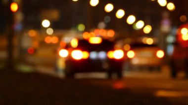 Gece giden bulanık arabalar, odaklanmamış trafik ışıkları, video görüntüleri.