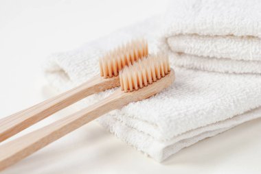 Bitki bazlı bambu diş fırçaları beyaz havluda, organik biyolojik olarak çözünebilir diş fırçası yakın plan.