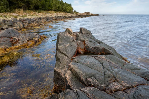 Ein Fels gegen blaues Wasser. Bild aus Skalderviken, Schweden — Stockfoto