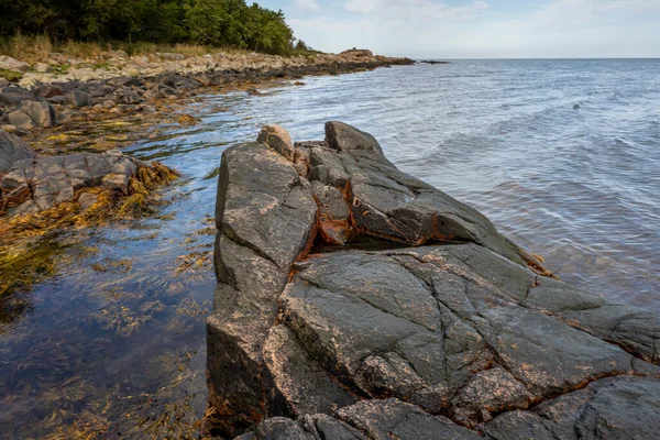 Ein Fels gegen blaues Wasser. Bild aus Skalderviken, Schweden — Stockfoto