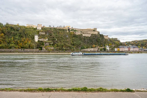 Deutsche Ecke, Koblenz waren Rhein und Mosel. Im Vordergrund ein Binnenschiff mit der Festung Ehrenbreitstein im Hintergrund — Stockfoto