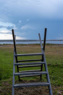 Bozkırda bir çitin üzerinde merdiven