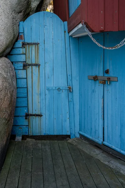 An old blue wooden door next to a rock formation