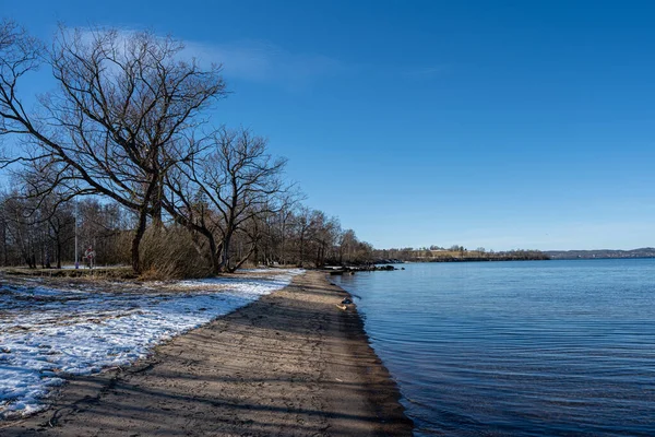 A lake winter beach covered with snow and a blue sky in the background — Stock Photo, Image