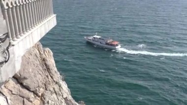 Bir deniz teknesi Kırlangıç Yuvası 'nın yakınından geçiyor. Kırım' ın güney kıyısının amblemi olan bir deniz yamacındaki Gotik şato. 40 metrelik Aurora uçurumunda, Bolshaya Yalta 'daki El-Todor Kafe' de..