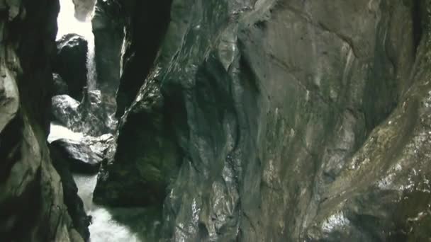 山の川は狭い岩の間を流れている 水は岩の上で激しく壊れ 泡立ち 動き続けています 水の近くの岩そのもの 水が石を破った 野生の自然 — ストック動画