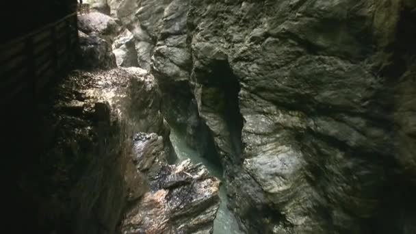 山の川は狭い岩の間を流れている 水は岩の上で激しく壊れ 泡立ち 動き続けています 水の近くの岩そのもの 水が石を破った 野生の自然 — ストック動画