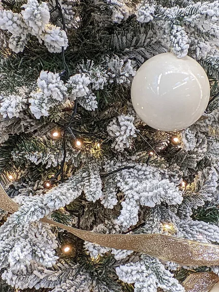 Noel ağacının karla kaplı dallarında yeni yıl oyuncakları. Cam küre, boncuklar. Şenlik arka planı. Yeni Yıl ve Noel. 