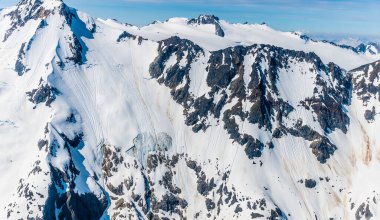 Yazın Skagway, Alaska 'ya yakın Denver buzulunun üzerindeki dağ zirveleri ve dik duvarlar.